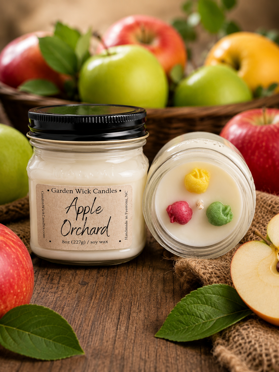 Garden Wick Apple Orchard 100% soy candle with colorful apple wax embeds, featuring the fresh scent of ripe apples with bright fruit notes and a touch of spice. Fragrance notes include orange peel, nutmeg, apple, clove, and vanilla for a cozy orchard-inspired aroma.