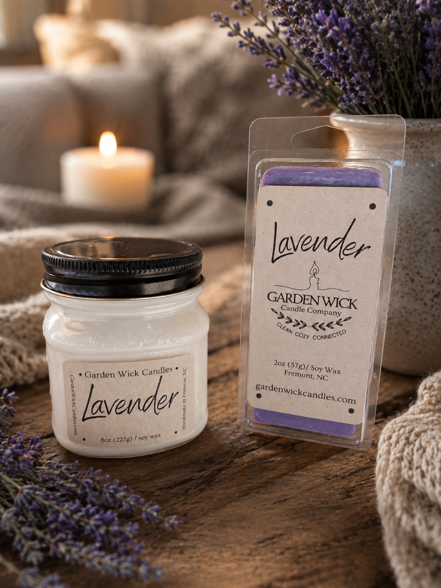 Lavender candle and wax melt with packaging on a wooden surface, surrounded by lavender flowers. Clean, non-toxic, soy way by garden wick.